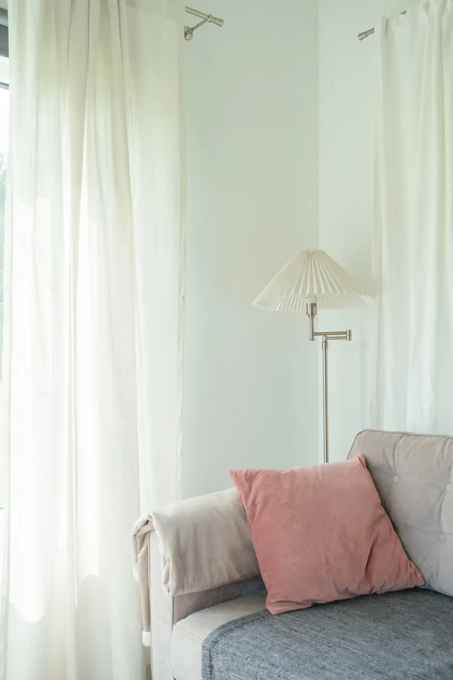 A quiet corner of the living room: reading lamp, sofa and linen curtains